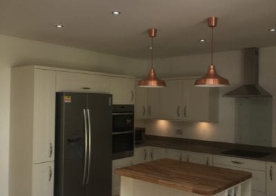 Photo of a completed kitchen after construction with brass light fittings