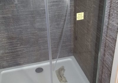 Bathroom shower with white tray and texture mosaics on the walls